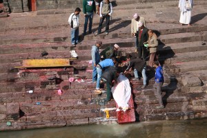 on the left of the photo there were four pyres burning and on the right were people bathing in the river. 